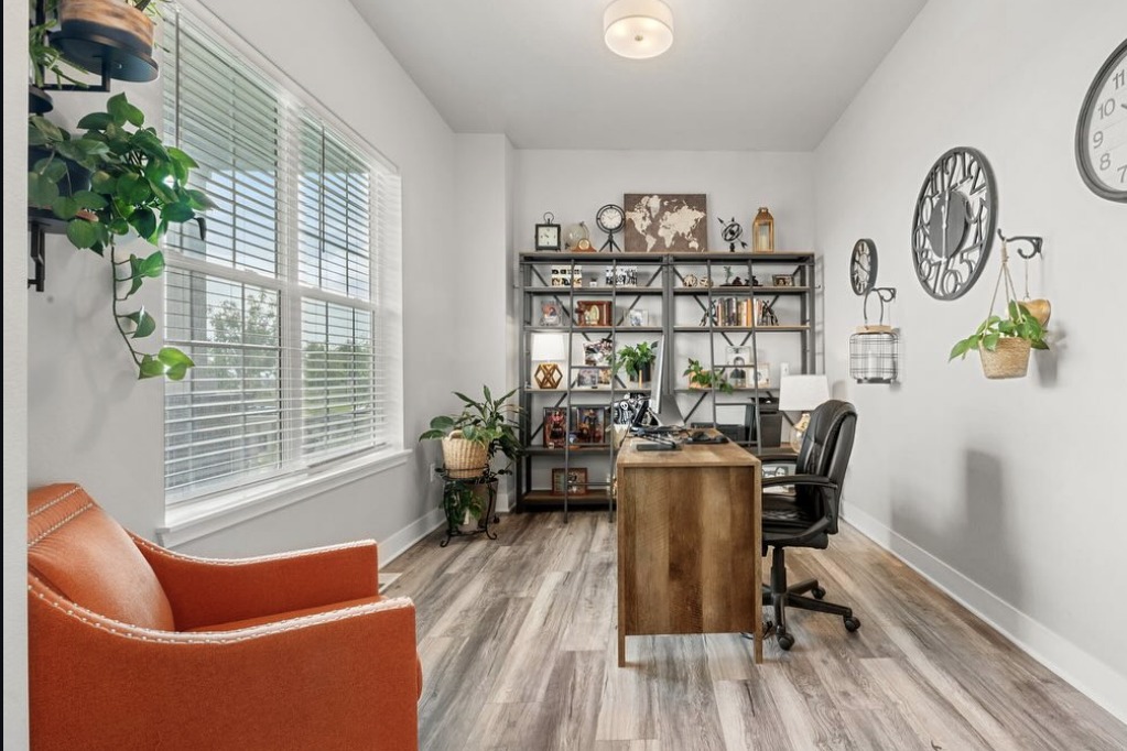 Home office with an orange armchair and wall clocks