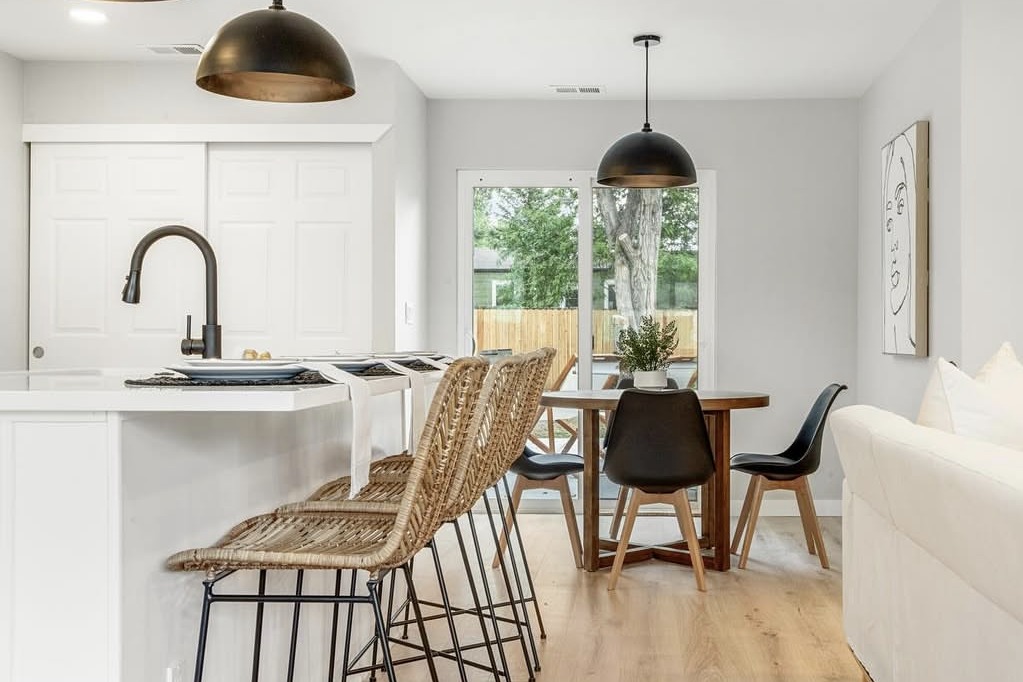 Kitchen island with rattan barstools next to the dining area