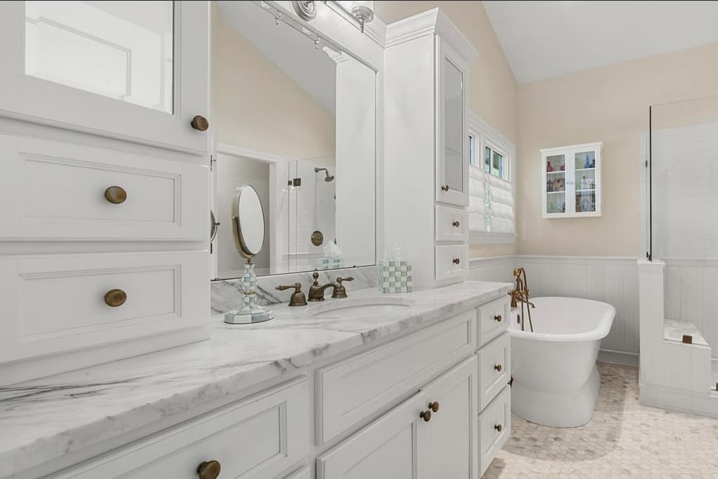 Primary bathroom with a marble double vanity and soaking tub