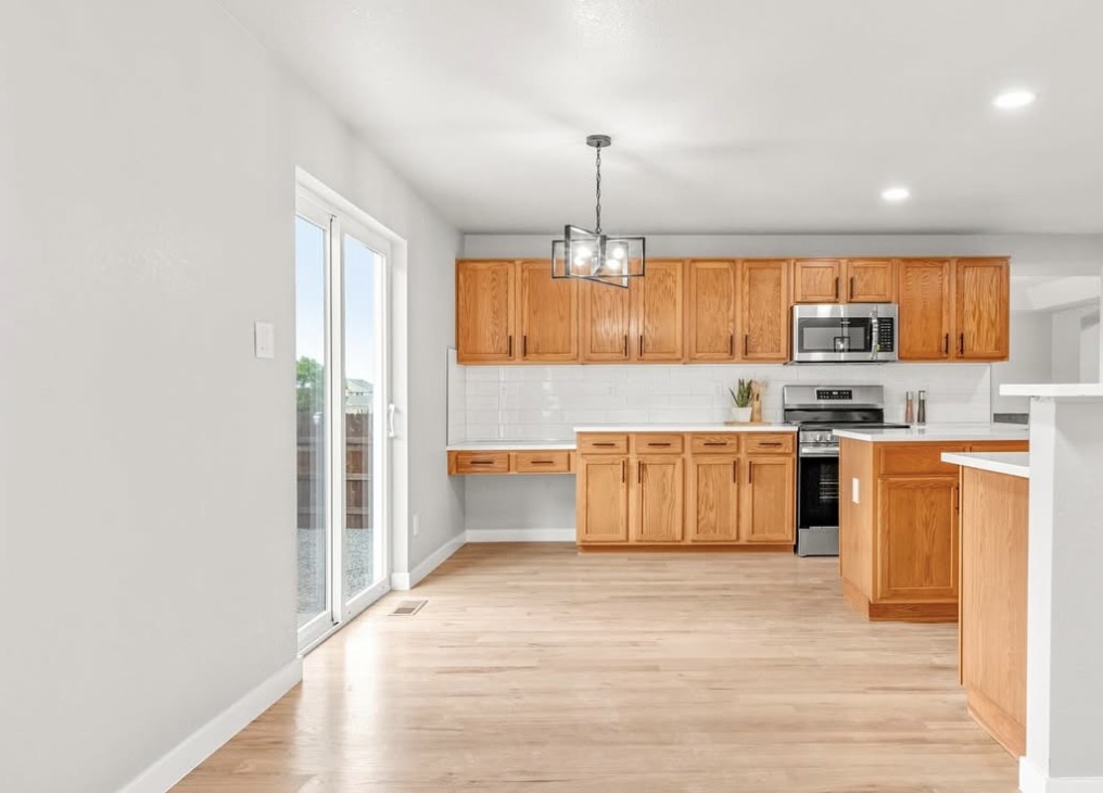 Vacant kitchen with oak cabinets, stainless appliances and patio door