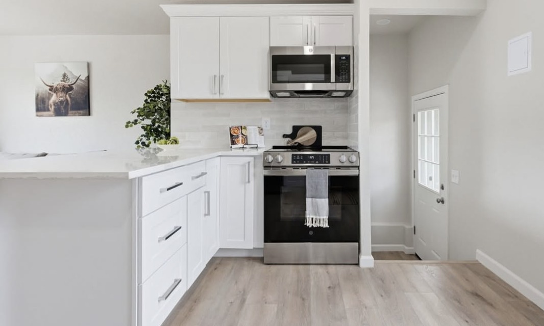 Kitchen with a gas range and white shaker cabinets