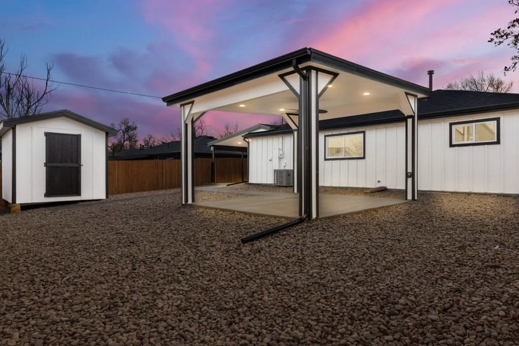 Twilight backyard with a covered patio and storage shed