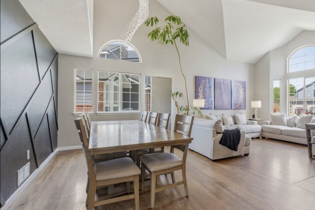 Vaulted dining and living room with an accent wall