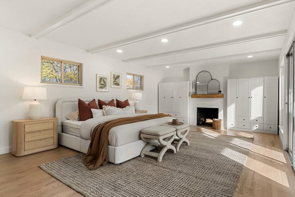 Primary bedroom with a beamed ceiling and fireplace