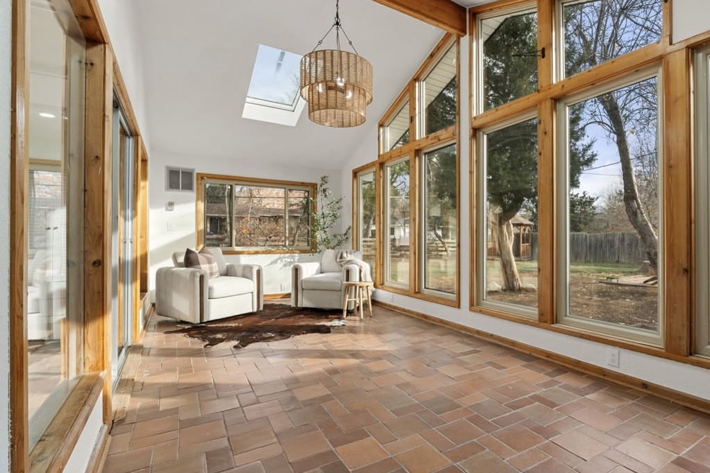 Sunroom with wood-framed windows and a skylight