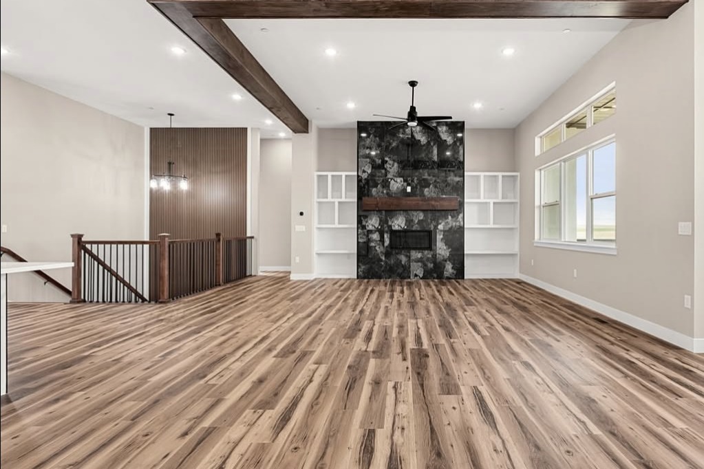 Great room with wood beams and a stone fireplace