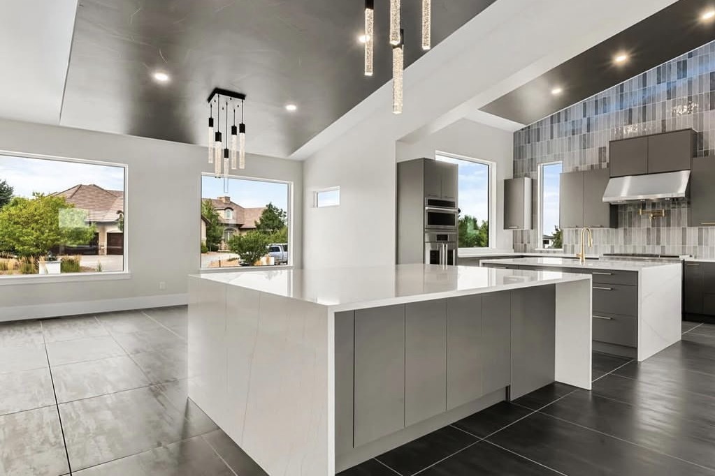 Modern kitchen with a waterfall island and dark tile floors
