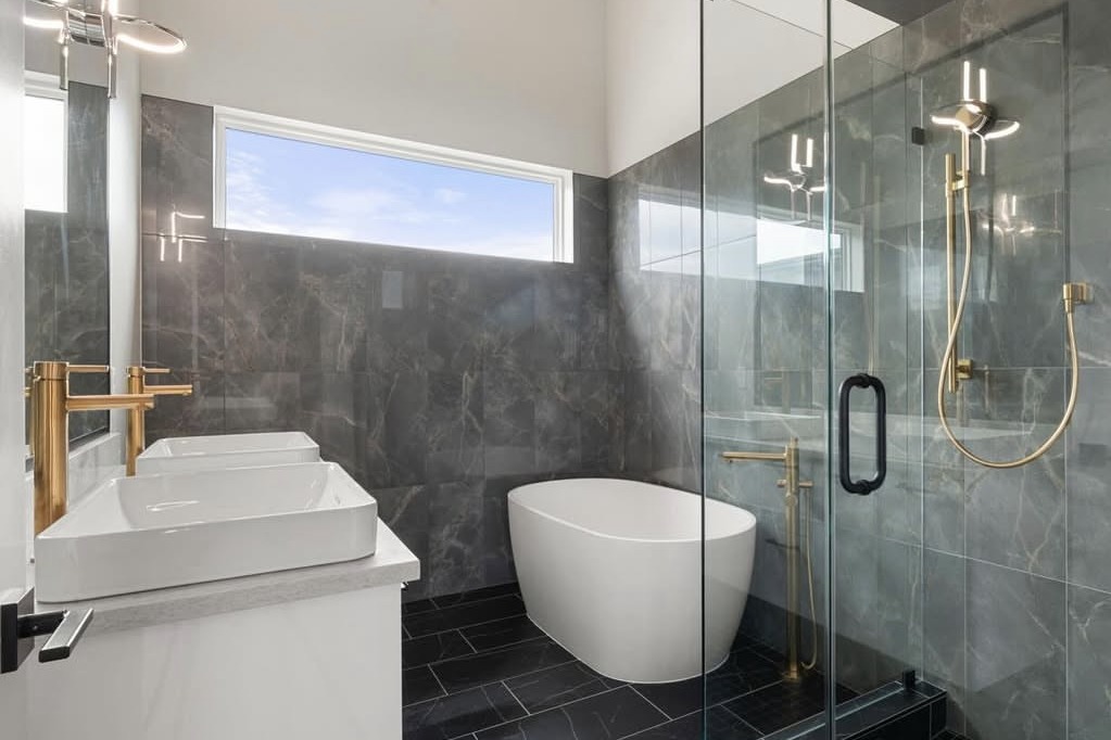 Bathroom with gold fixtures, a freestanding tub and walk-in shower