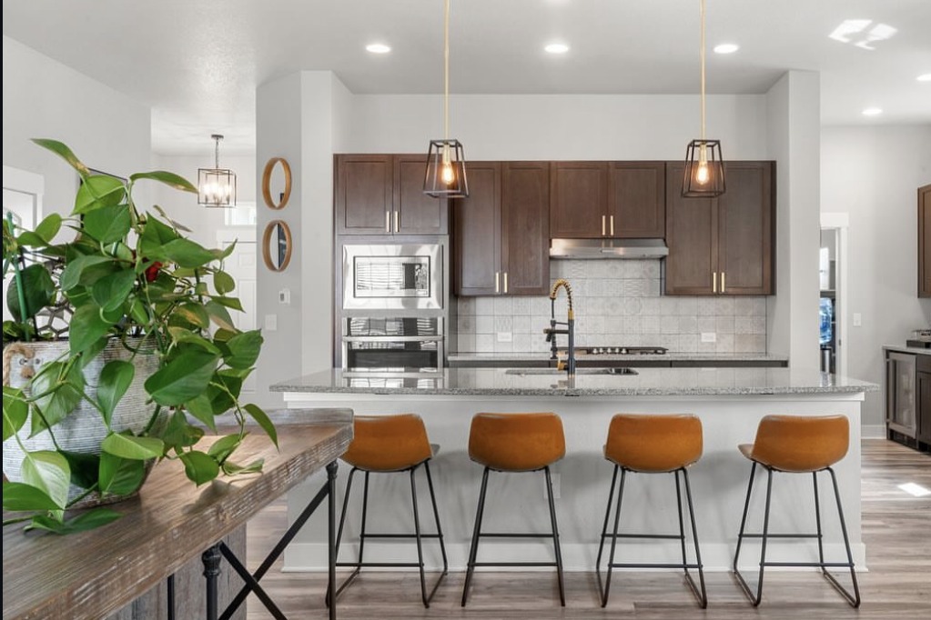 Kitchen island with leather barstools and pendant lights