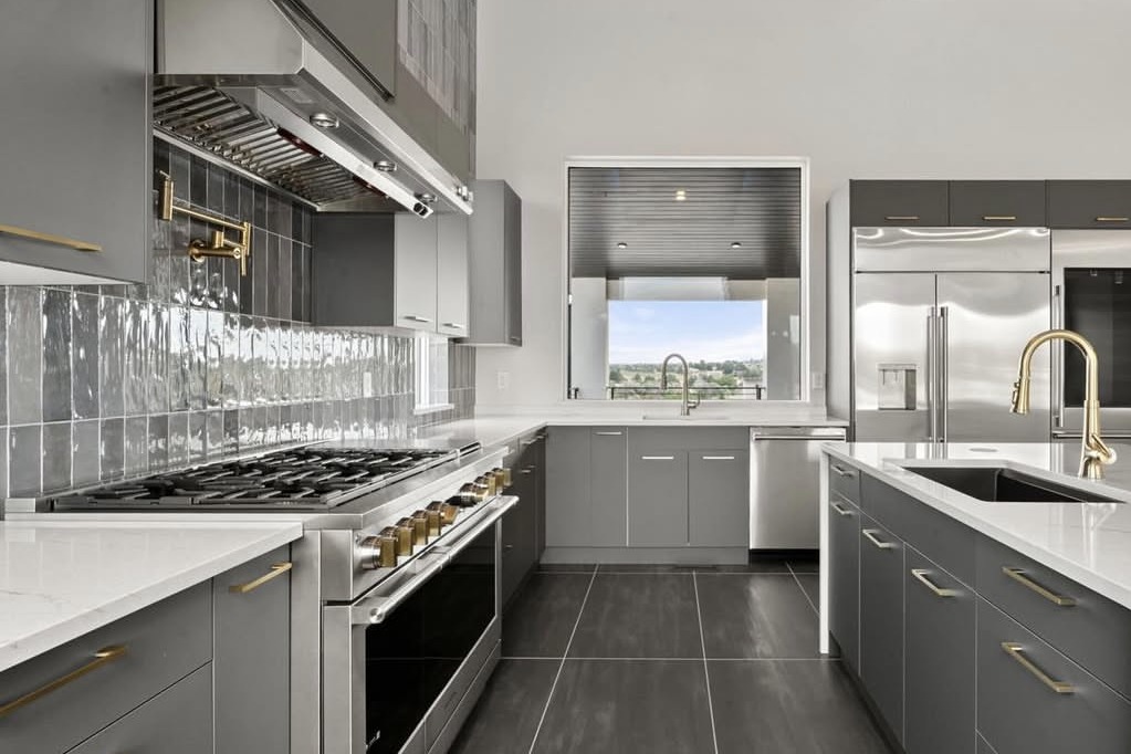 Chef's kitchen with gold pot filler and gray cabinets