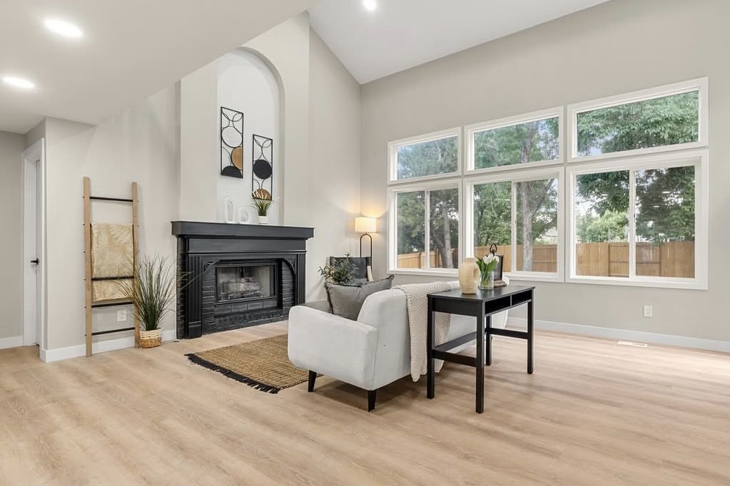 Vaulted living room with tall windows and a fireplace
